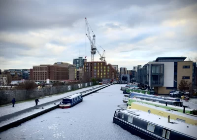 Fountainbridge (Edinburgh, Scotland) canal is covered in ice and boats are docked.